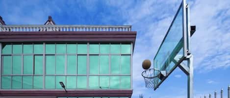 A building with large windows and a basketball hoop.