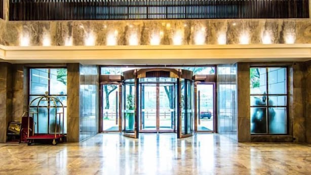 A lobby with a revolving door, marble flooring, and large windows. - TONGXINLAKE HOTEL (You County)