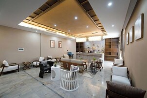 Un interior moderno con una recepción, zona de estar y obras de arte en las paredes.