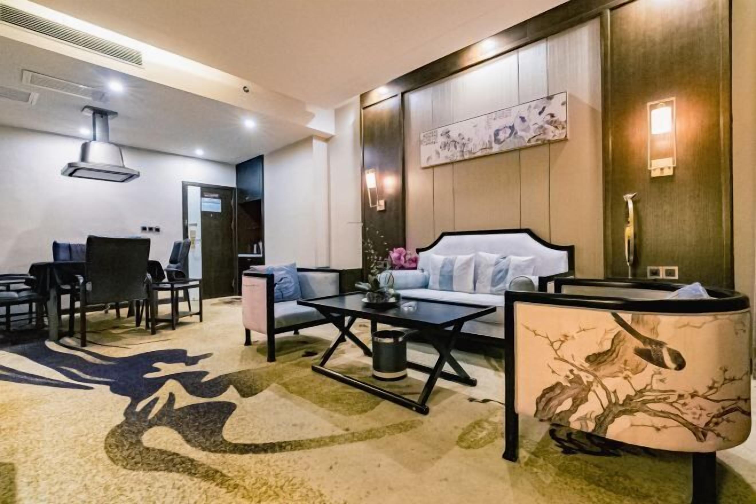 Una habitación de hotel moderna con sofá, una mesa de centro y un comedor con sillas.