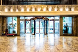 Eine Lobby mit einer Drehtür und einem Glastür-Eingang.