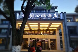 A hotel entrance with a modern design, featuring a prominent sign and a covered entrance area. - TONGXINLAKE HOTEL (You County)