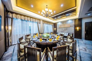 A dining area with a round table, chairs, and a chandelier. - TONGXINLAKE HOTEL (You County)
