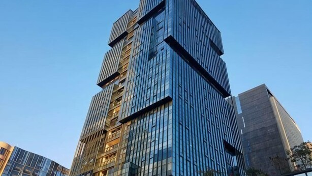 Un immeuble de grande hauteur doté d’une façade moderne en verre, de nombreux étages et d’un élément de design vertical particulièrement visible.