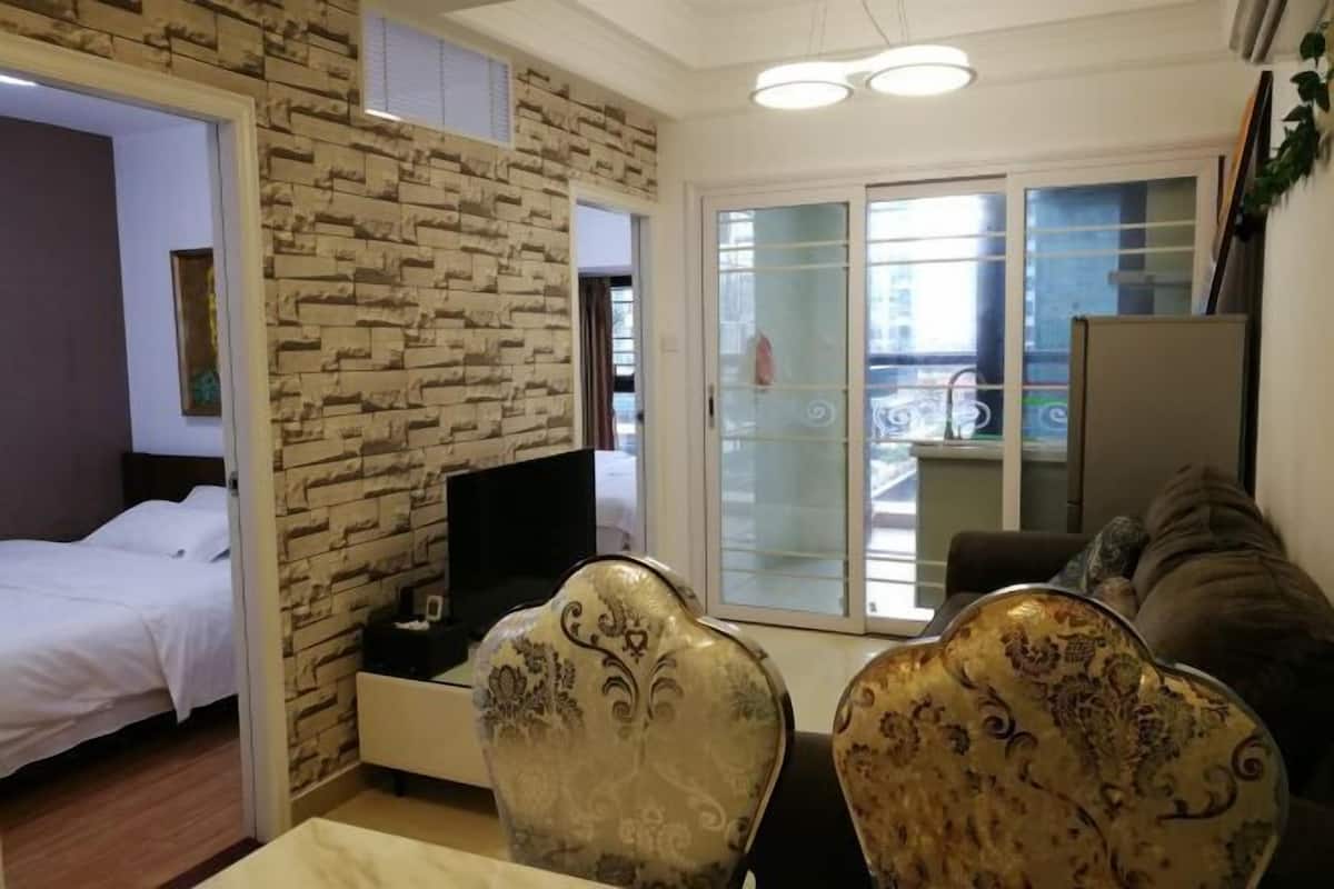 Una habitación de hotel con cama, televisor, mesa de comedor y sofá.