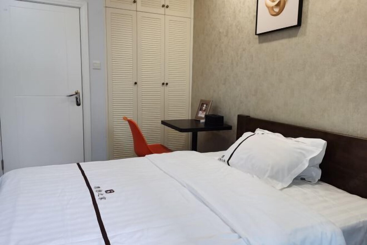 Une chambre d’hôtel avec un lit, une chaise, une petite table et une armoire.