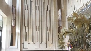 Un intérieur moderne avec un motif géométrique sur un mur, un sol carrelé et une composition florale.