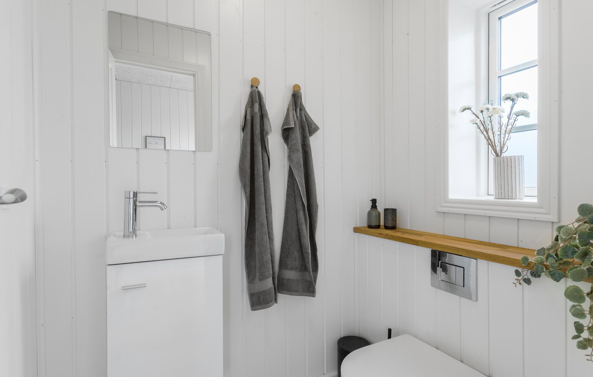 Ein Badezimmer mit Waschbecken, Spiegel und Handtuchhalter.