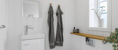 Ein Badezimmer mit Waschbecken, Spiegel und Handtuchhalter.