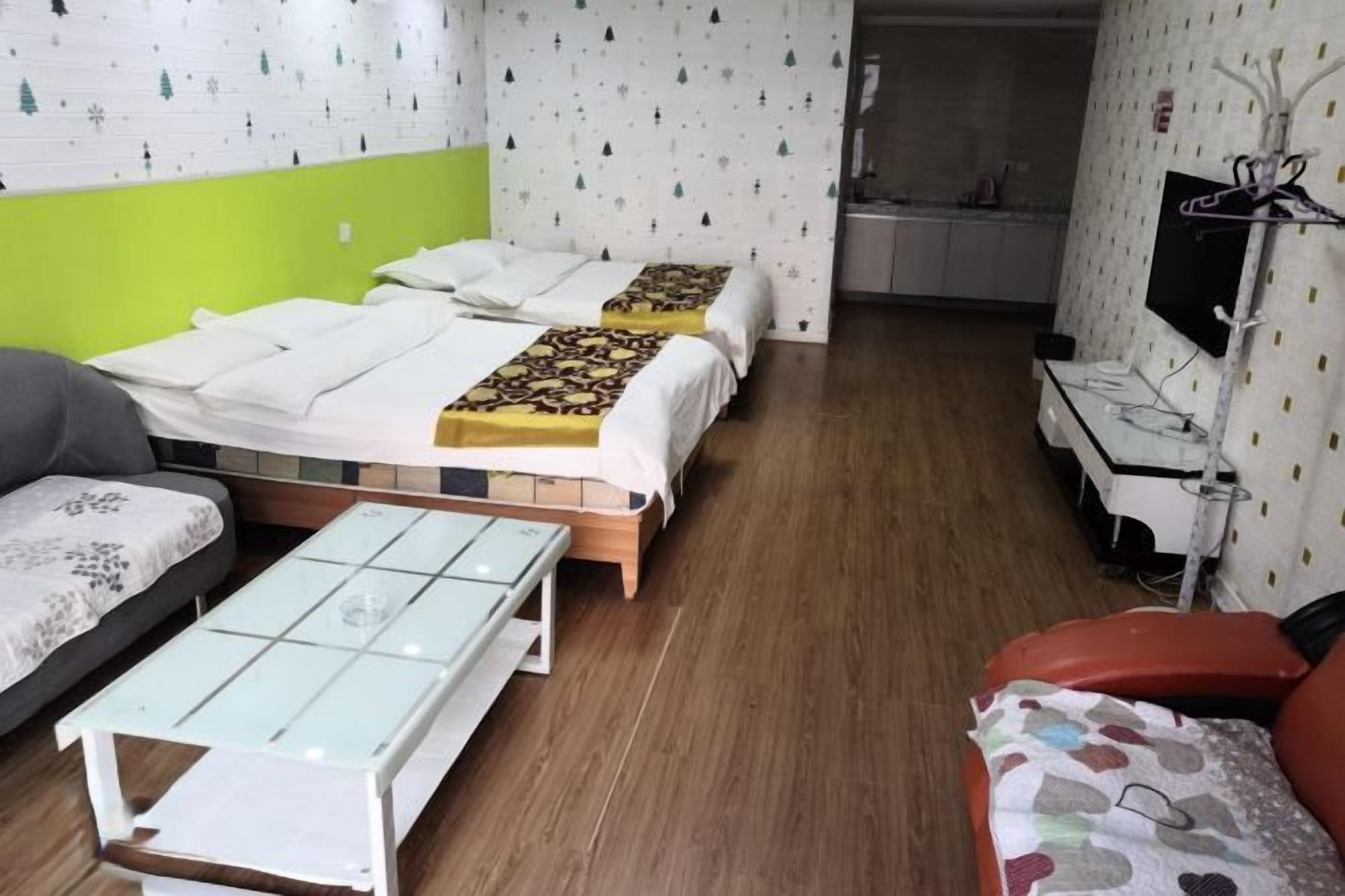 A hotel room with a bed, a sofa, a small table, and a TV.