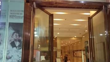 Un pasillo interior con puertas de vidrio que dan a una zona de recepción.
