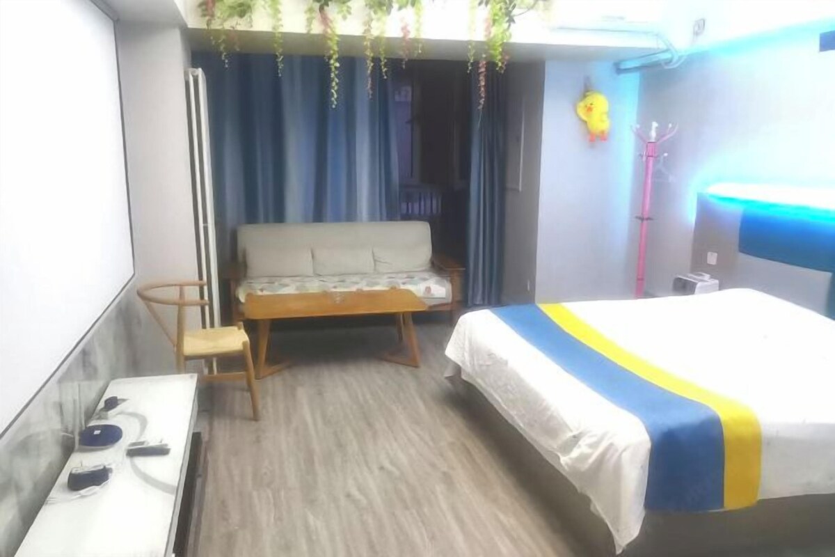 A hotel room with a bed, a sofa, a desk, and a chair.