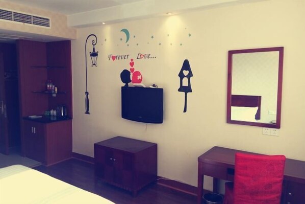 A hotel room with a bed, a small desk, a TV, and a wall with decorative items including a crescent moon, stars, and a heart with the words "Forever Love...". - Wanhao Hotel (Cixi)
