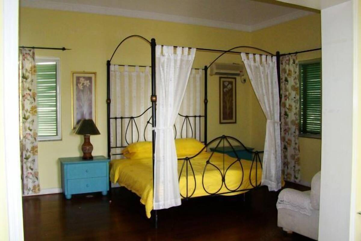 Un lit à baldaquin, une table de chevet avec une lampe et une chaise.