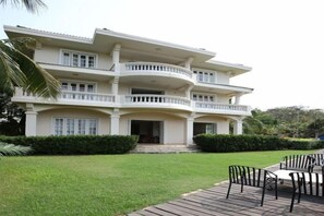 A multi-story building with a large front porch, a covered outdoor seating area, and a well-maintained lawn. - Venus Garden Villa(Sanya Dadonghai Summer Department) (Sanya)