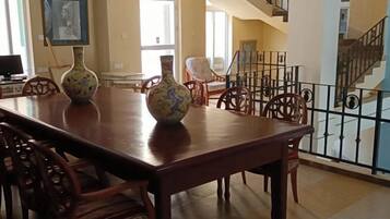 A dining area with a long wooden table, chairs, and decorative vases.