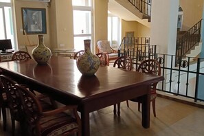 A dining area with a long wooden table, chairs, and decorative vases. - Venus Garden Villa(Sanya Dadonghai Summer Department) (Sanya)