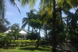 Uma rede em um jardim exuberante sob um céu limpo.