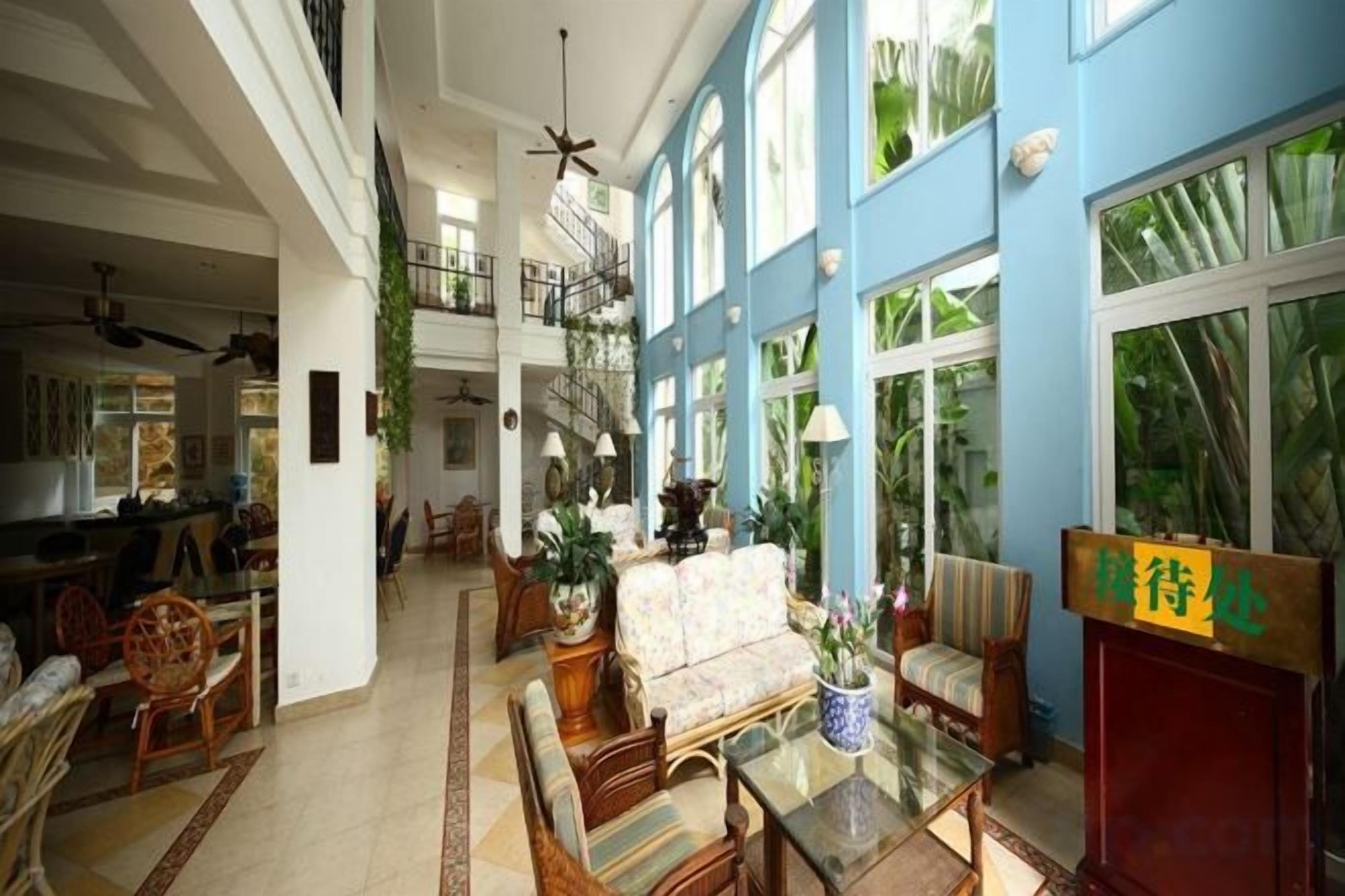 A spacious indoor area with a high ceiling, a staircase, and a seating area with a table and chairs.