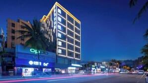 A modern hotel with a prominent 'OKO' sign, multiple floors, and a well-lit facade. - Haikou Meizhiyuesu Hotel (Farming Middle School) (Haikou)