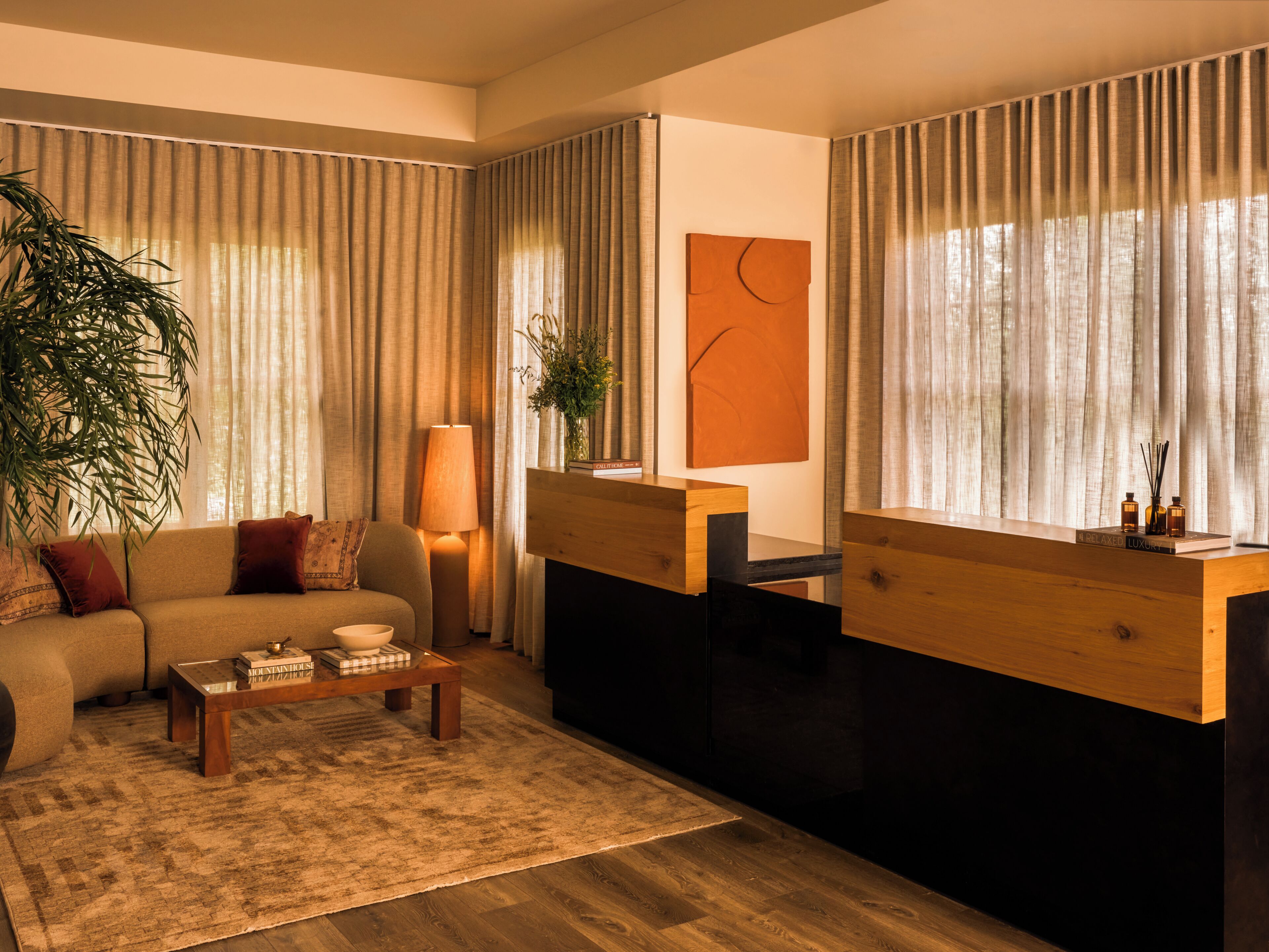 A modern living room with a sofa, coffee table, and a desk area.