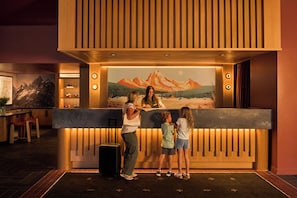 A reception desk with a wooden panel design and a painting of a mountain landscape.