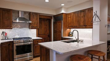 A kitchen with wooden cabinets, a stainless steel stove, and a marble countertop.