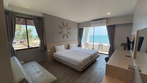 A modern hotel room with a large bed, a desk, and a view of the ocean. - Rayong Chalet Hotel and Resort (Klaeng)