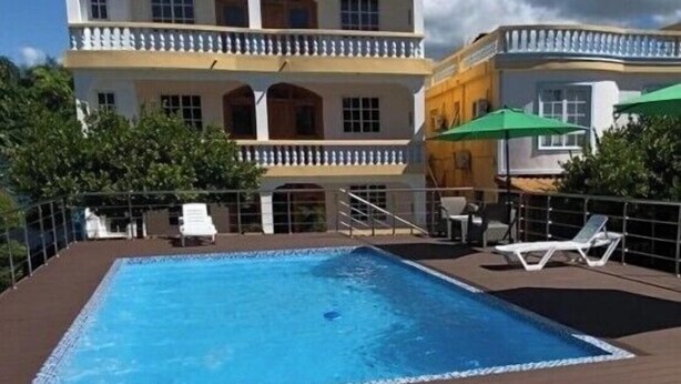 A two-story building with a swimming pool and outdoor seating.
