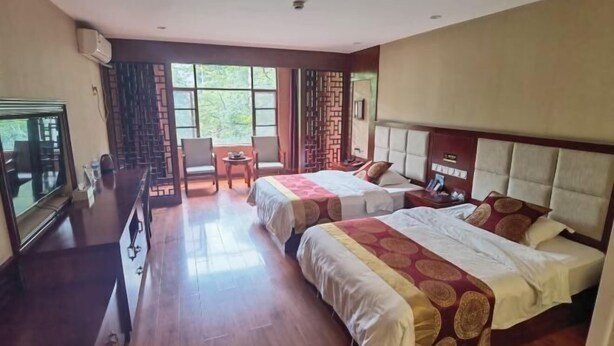 A hotel room with two beds, a desk, a chair, and a TV. - Jiangcheng Lindeng Hotel (Jiangcheng)