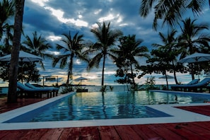 Una piscina al aire libre, sombrillas, sillones reclinables de piscina