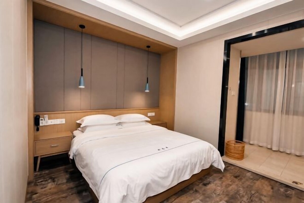 A modern bedroom with a large bed, bedside tables, and a built-in wardrobe.