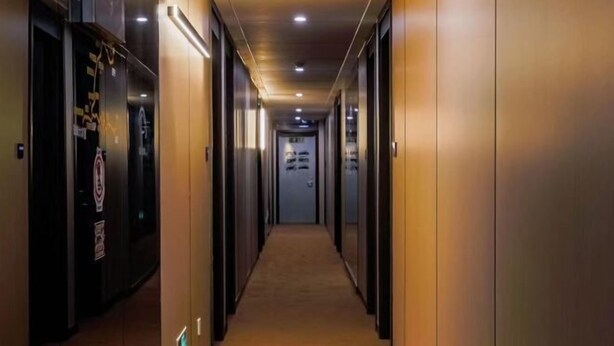 A hallway with doors on both sides, recessed lighting, and a carpeted floor. - GT New Element Hotel (Ningbo)