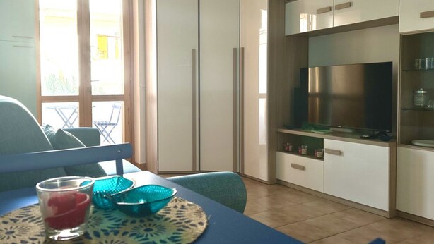 Eine moderne Küche mit einem eingebauten Kühlschrank, einem Esstisch mit Stühlen und einem Fenster mit Blick nach draußen.
