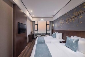 A hotel room with two beds, a flat-screen TV, a small table, and a view of the outdoors. - Zhualongxi Garden Hotel (Jintang)