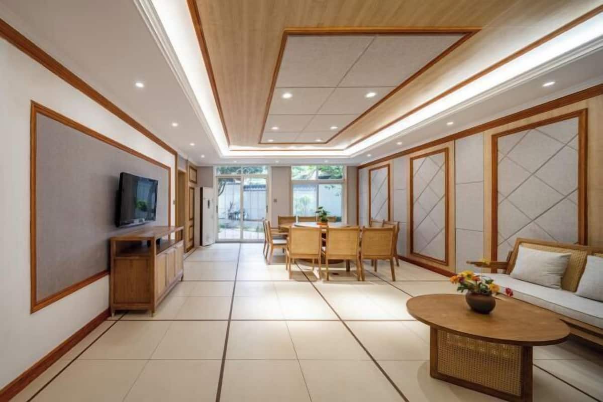 A modern living room with a dining area, a television, and a sofa.
