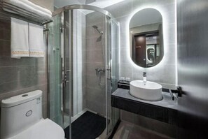 A modern bathroom with a glass-enclosed shower, a white toilet, a sink with a mirror, and a towel rack. - Zhualongxi Garden Hotel (Jintang)