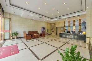 A hotel lobby with a reception desk, seating area, and a large window with a view. - Maple Leaf Hotel (Lipu) (Lipu)