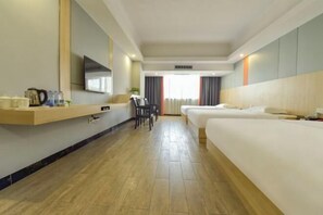 A hotel room with a bed, a desk, a chair, a television, and a window with curtains. - Maple Leaf Hotel (Lipu) (Lipu)