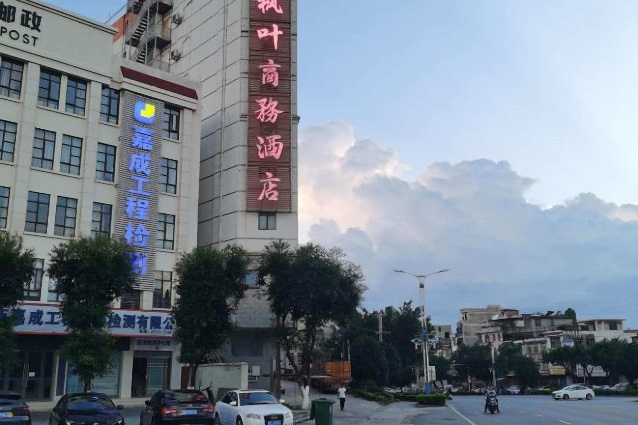Un edificio con letreros de un hotel y un negocio, con un logotipo visible.