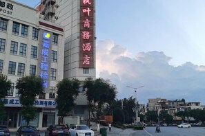 Un edificio con letreros de un hotel y un negocio, con un logotipo visible.