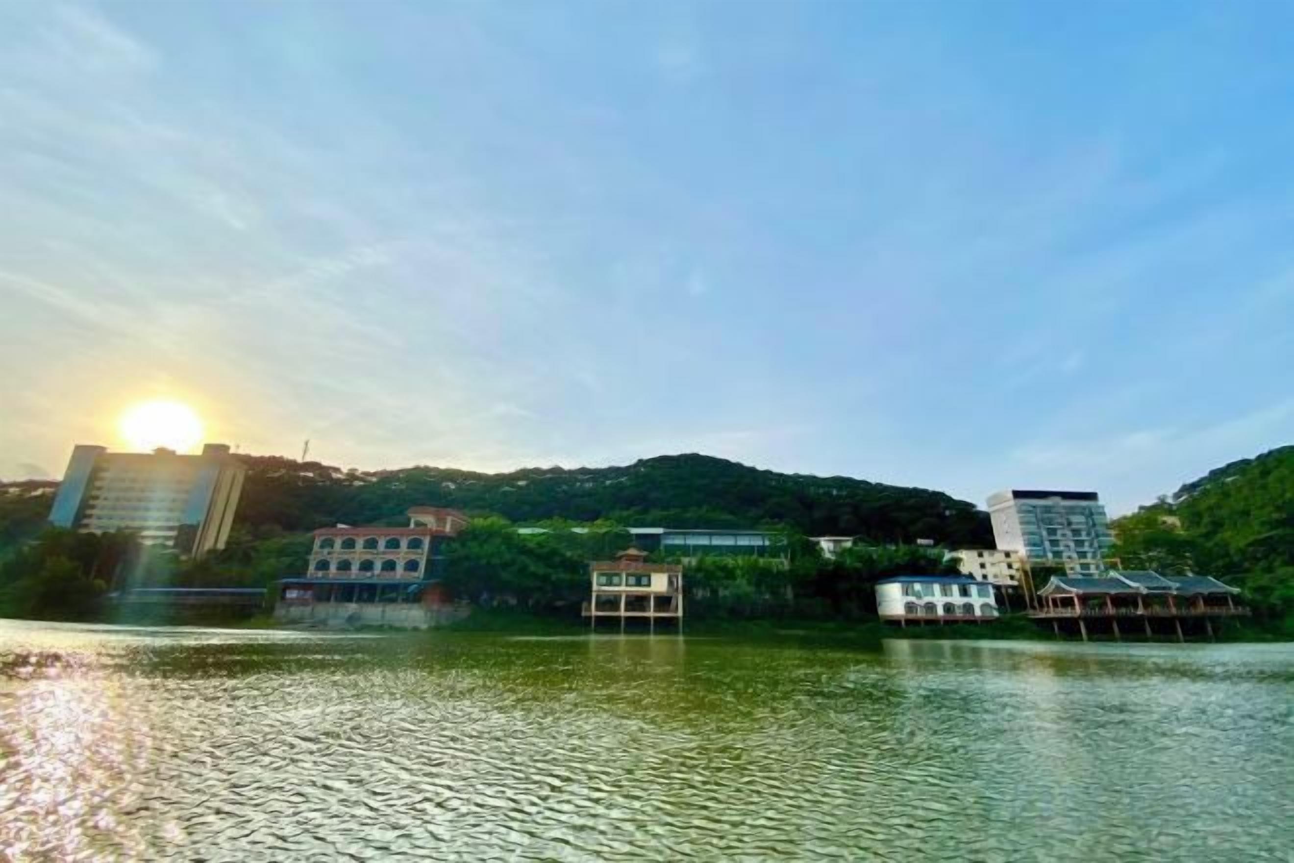 A lakeside view with buildings and a dock.