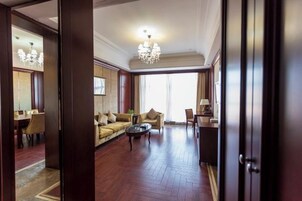 Un salón amplio con sofá, mesa de centro y candelabro.