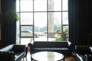 Una habitación con un ventanal grande, una mesa redonda y dos sofás.