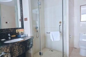 Un baño moderno con ducha de vidrio, lavamanos con encimera de mármol y retrete.