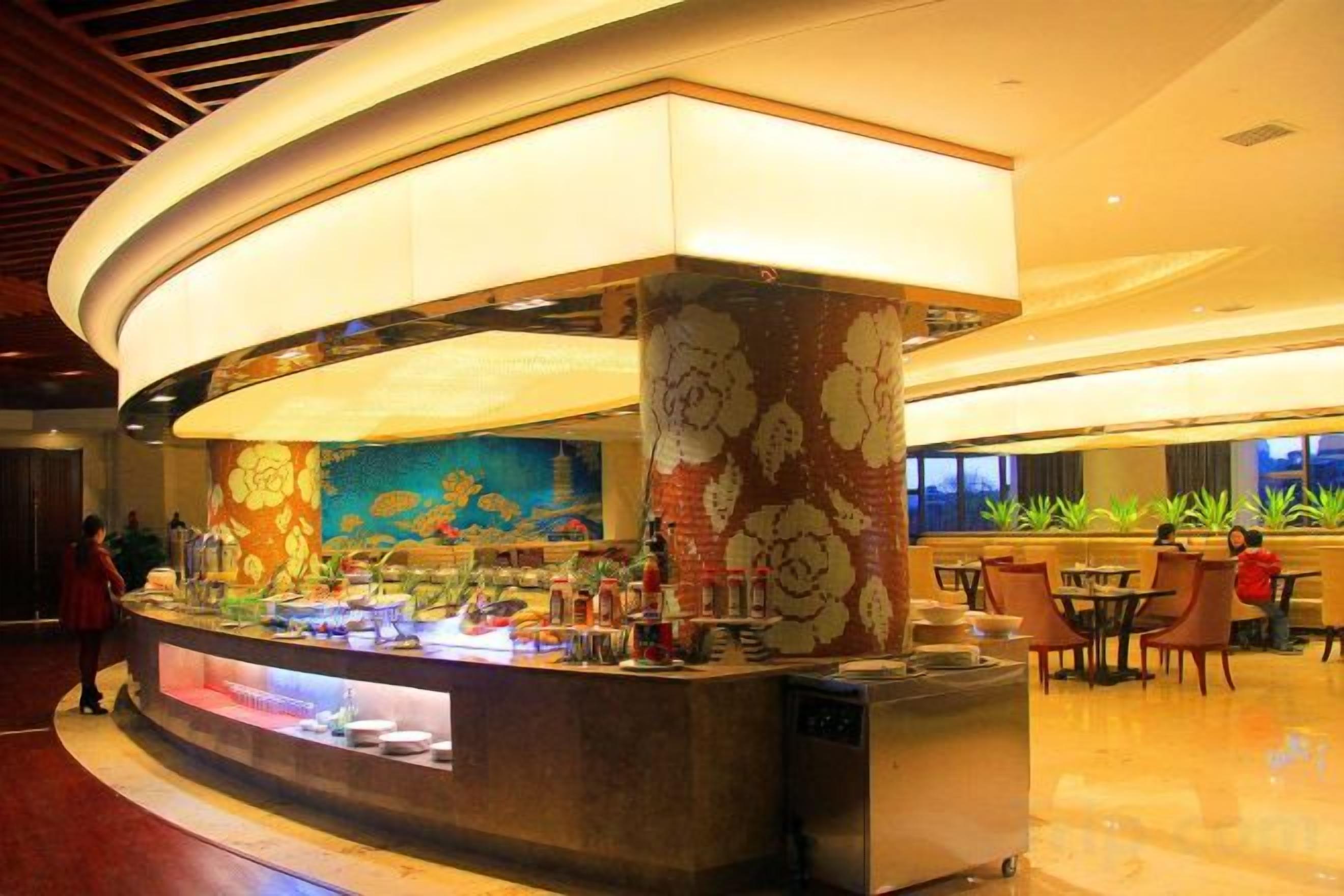 A hotel lobby with a curved reception desk, a large aquarium, and seating areas.
