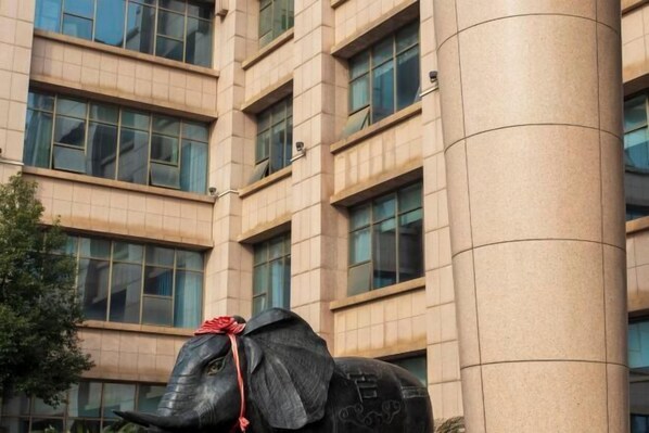 A building with a large column and a statue of an elephant wearing a red ribbon. - Furong International Hotel (Yongxiu)
