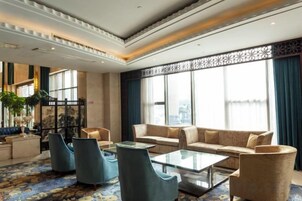 Un vestíbulo amplio con un conjunto de sofás, sillones y una mesa de centro.
