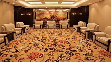 A conference room with a patterned carpet, round tables, and chairs arranged for meetings.