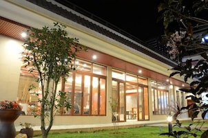 Un edificio moderno con amplios ventanales, techo plano e iluminación exterior.